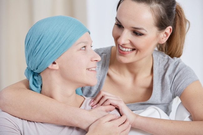 Hopeful cancer woman wearing headscarf talking with friend